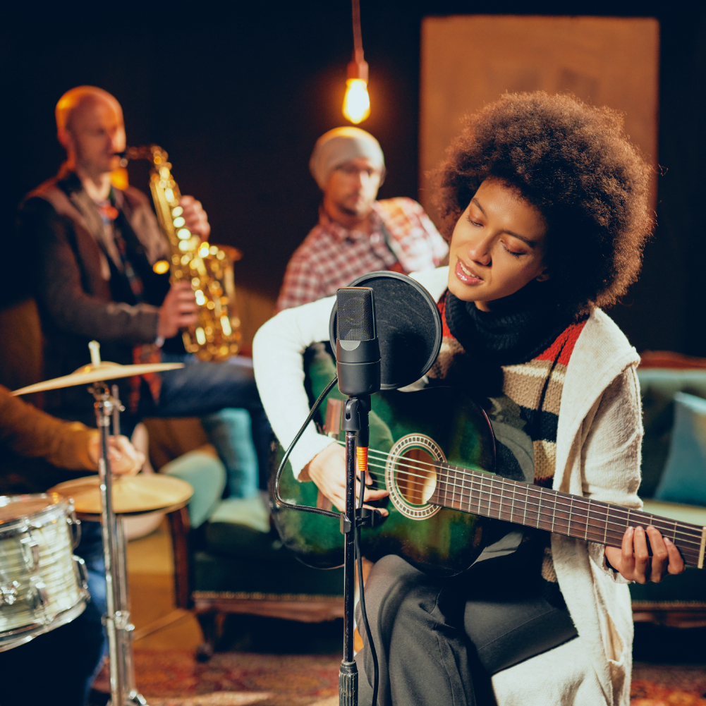 woman playing guitar with a band in cozy session