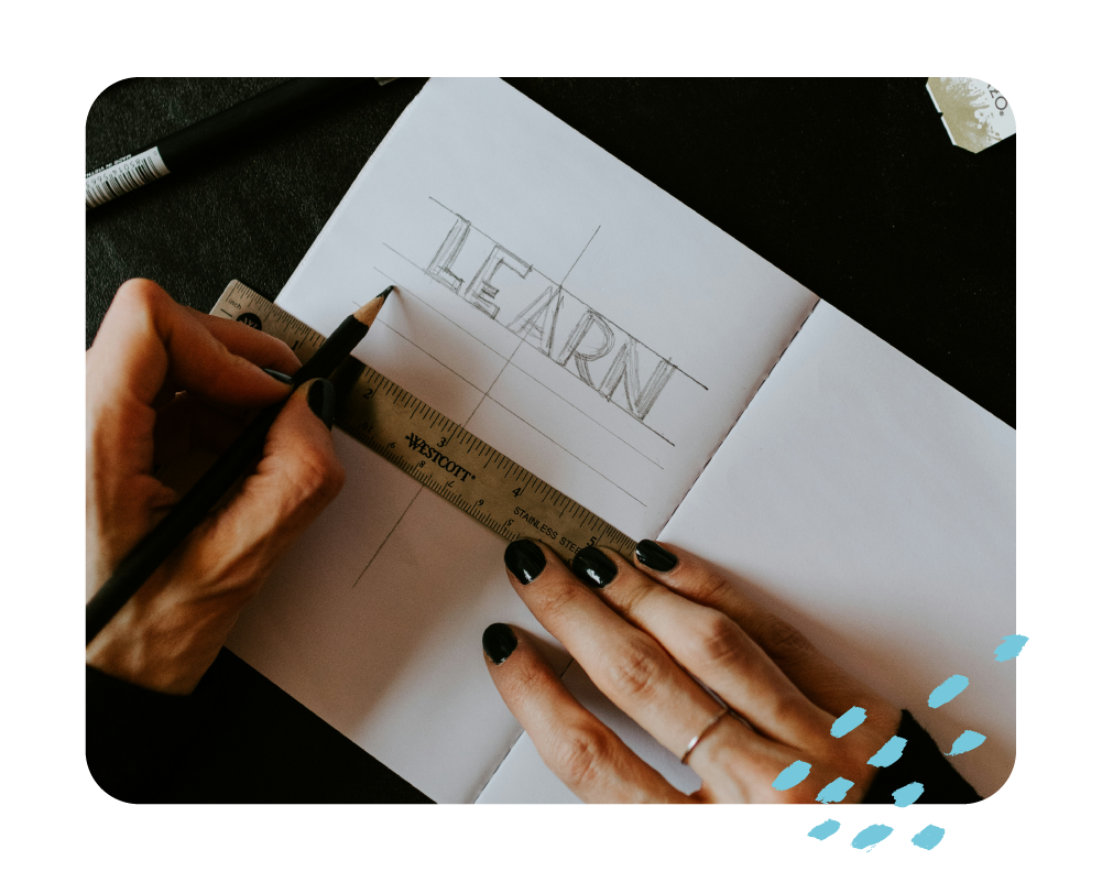 woman drawing learn in lettering on a handbook